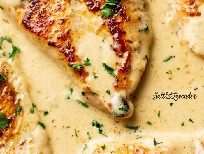 Creamy Garlic Parmesan Chicken served with herbs and a side dish