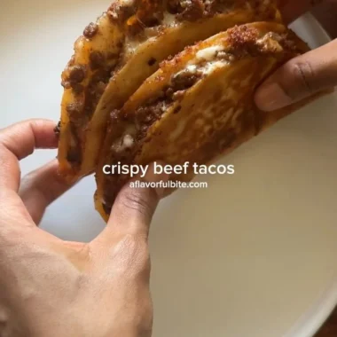 Crispy ground beef tacos with fresh toppings on a wooden table