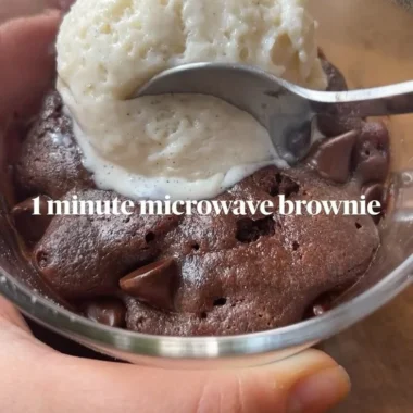 Fudgy brownie mug cake topped with chocolate chips in a mug