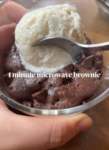 Fudgy brownie mug cake topped with chocolate chips in a mug