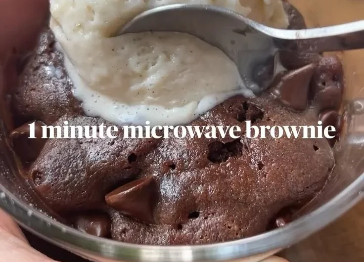 Fudgy brownie mug cake topped with chocolate chips in a mug