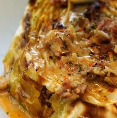 Vegetarian cabbage steaks with sun-dried tomato cream sauce on a plate