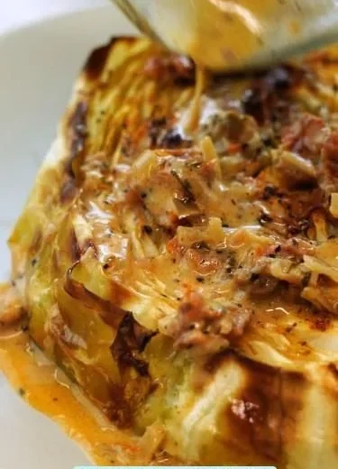 Vegetarian cabbage steaks with sun-dried tomato cream sauce on a plate