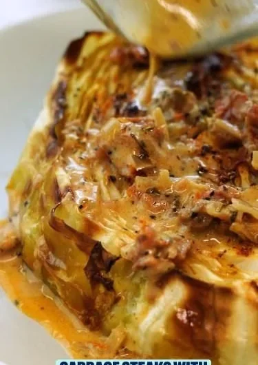 Vegetarian cabbage steaks with sun-dried tomato cream sauce on a plate