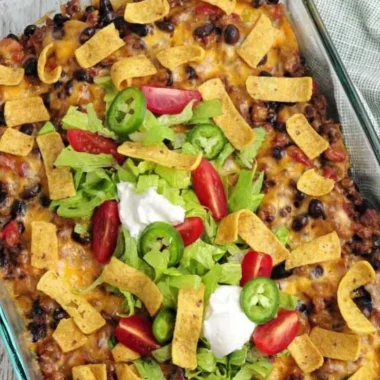 Delicious walking taco casserole served in a bowl with toppings.