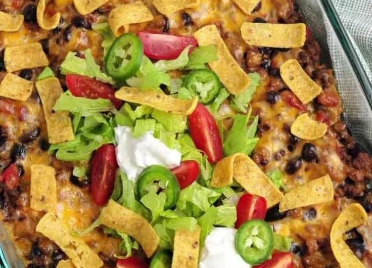 Delicious walking taco casserole served in a bowl with toppings.