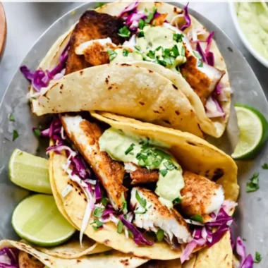 Delicious blackened fish tacos with avocado cream sauce on a plate
