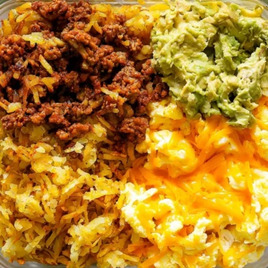 Healthy breakfast burrito bowl with eggs, veggies, and avocado