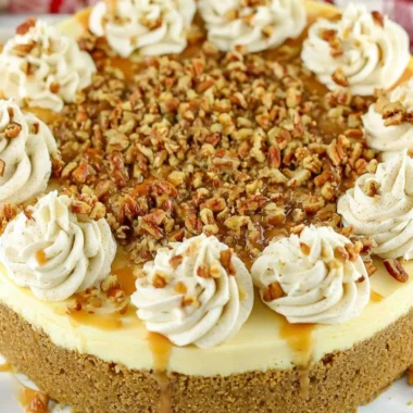 Slice of browned butter pecan cheesecake topped with toasted pecans