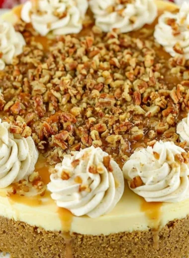 Slice of browned butter pecan cheesecake topped with toasted pecans