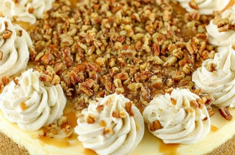 Slice of browned butter pecan cheesecake topped with toasted pecans