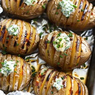 Cozy Hasselback potatoes topped with rich chive butter, perfect for any meal.