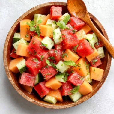 Fresh melon salad with honey lime dressing served in a bowl.