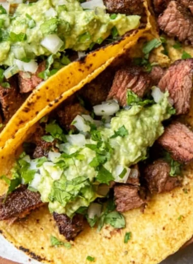 Delicious grilled steak tacos served with creamy avocado salsa