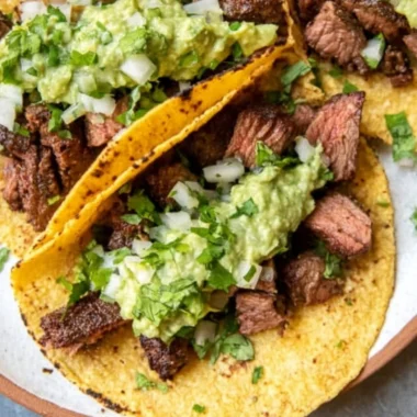 Grilled steak tacos served with vibrant avocado salsa on a plate