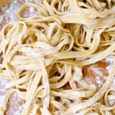 Freshly made homemade egg noodles on a wooden table