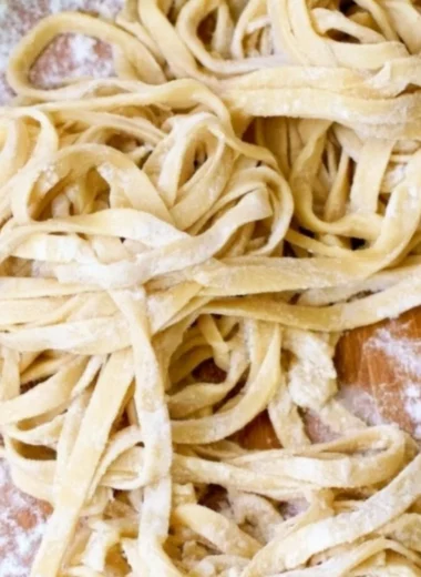Freshly made homemade egg noodles on a wooden table