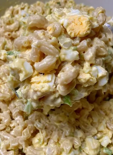 Homemade Mom's macaroni salad in a bowl with fresh vegetables
