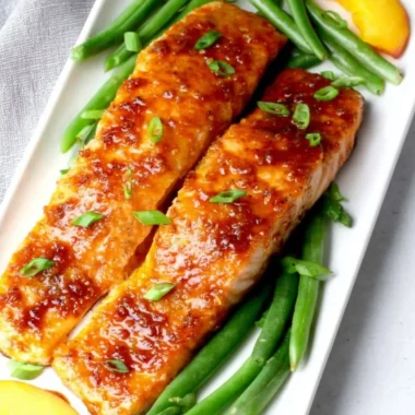 Delicious peach glazed salmon served with vibrant vegetables on a plate