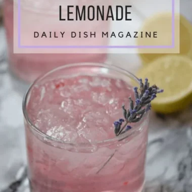 A refreshing glass of pink lavender lemonade garnished with lavender sprigs.