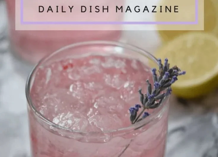 A refreshing glass of pink lavender lemonade garnished with lavender sprigs.