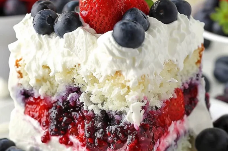 Delicious Summer Berry Poke Cake topped with fresh berries and whipped cream.