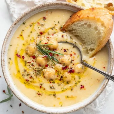 Bowl of Vegan Garlic Chickpea Soup garnished with herbs