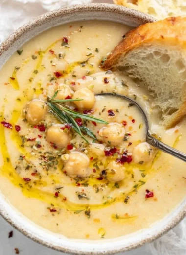 Bowl of Vegan Garlic Chickpea Soup garnished with herbs