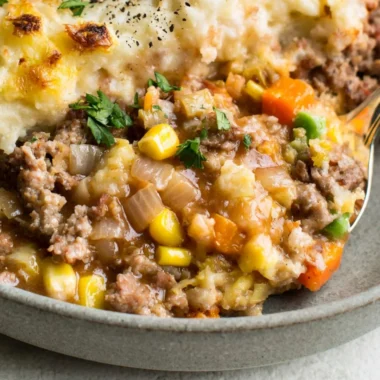Cozy Shepherd's Pie topped with golden mashed potatoes and fresh herbs.