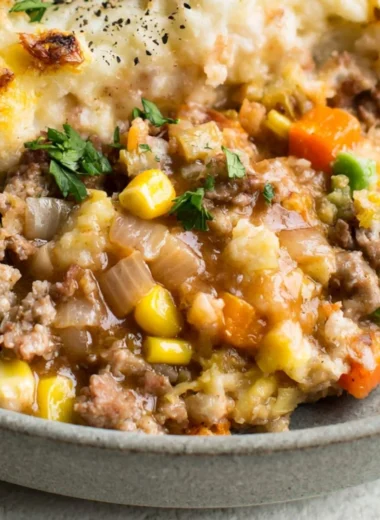 Cozy Shepherd's Pie topped with golden mashed potatoes and fresh herbs.