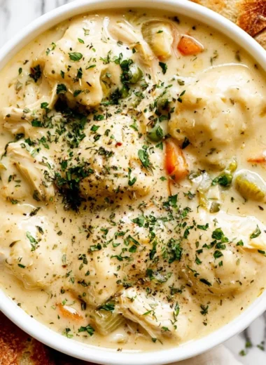 Bowls of cozy chicken dumpling soup with fresh herbs and vegetables