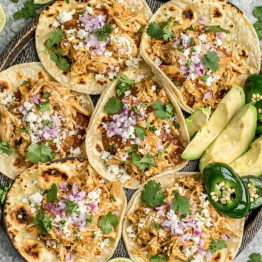 Cozy crockpot chicken tacos served on a plate with fresh toppings