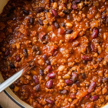 A bowl of cozy ground turkey chili garnished with fresh herbs and served with bread.