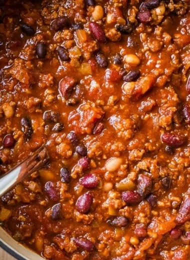 A bowl of cozy ground turkey chili garnished with fresh herbs and served with bread.