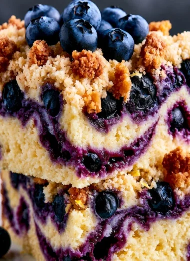 Slice of cozy lemon blueberry cake with fresh blueberries on top