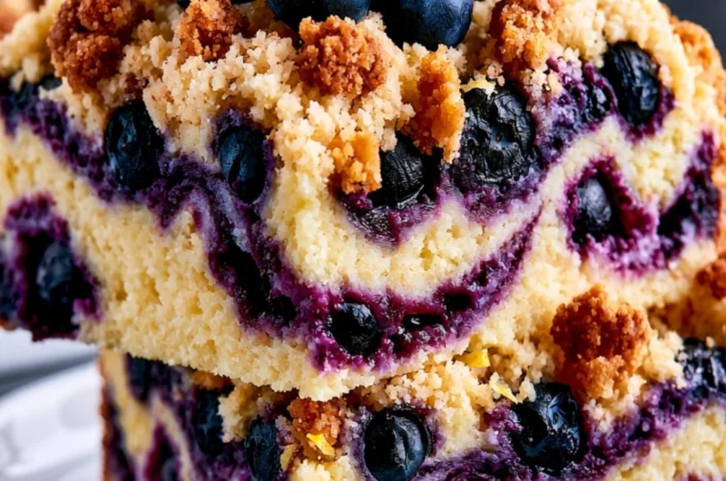 Slice of cozy lemon blueberry cake with fresh blueberries on top