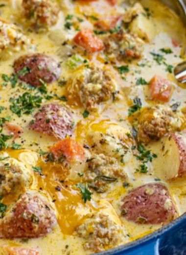 Bowl of creamy sausage potato soup garnished with herbs