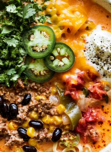 Bowl of creamy taco soup topped with cheese and cilantro, showcasing a delicious recipe.