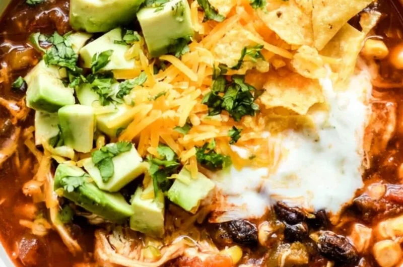 A bowl of hearty Crockpot chicken enchilada soup garnished with cilantro and cheese