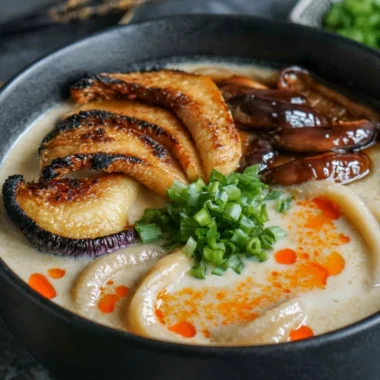 Bowl of miso udon noodle soup topped with teriyaki mushrooms