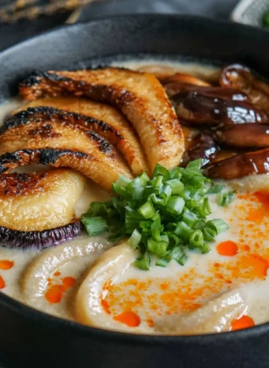 Bowl of miso udon noodle soup topped with teriyaki mushrooms