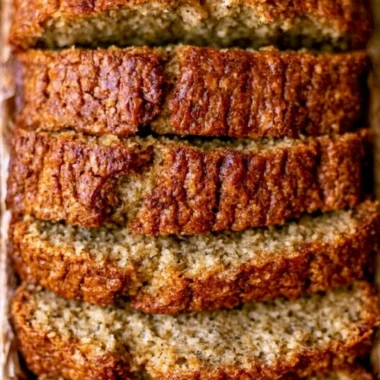 Moist banana bread with sour cream displayed on a wooden cutting board