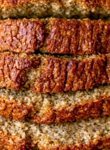 Moist banana bread with sour cream displayed on a wooden cutting board