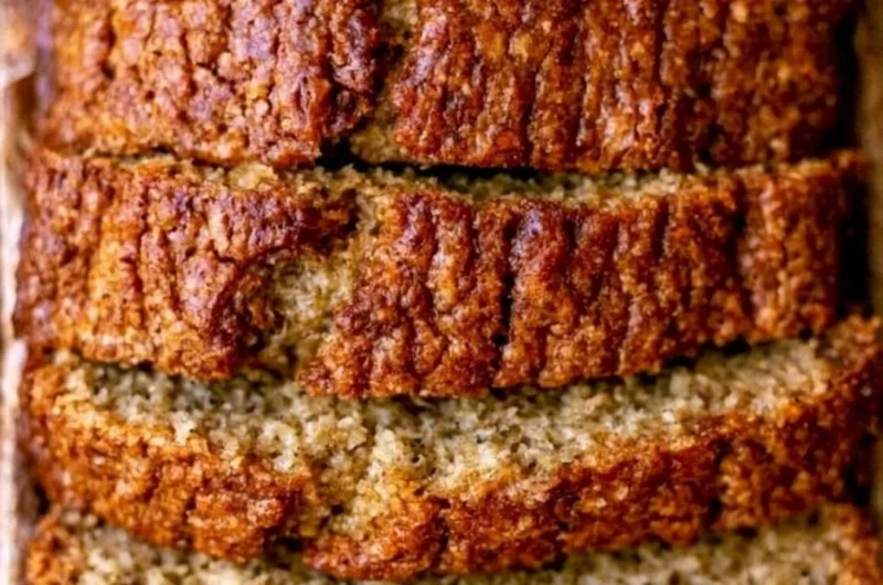 Moist banana bread with sour cream displayed on a wooden cutting board