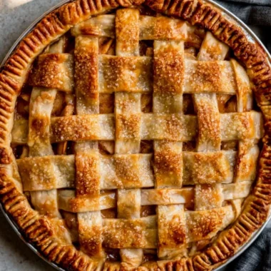 Delicious caramel apple pie topped with a caramel drizzle and apples.