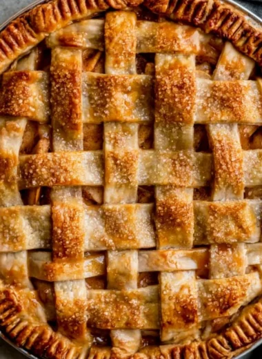 Delicious caramel apple pie topped with a caramel drizzle and apples.