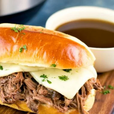 Delicious Instant Pot French dip sandwich with au jus on a rustic table