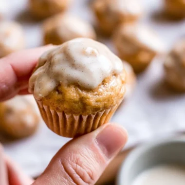 Mini chai muffins with vanilla bean glaze on a wooden table